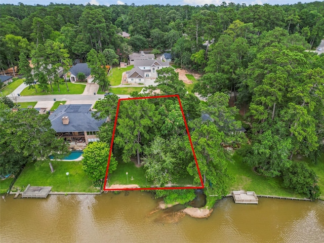 drone / aerial view with a water view and a forest view