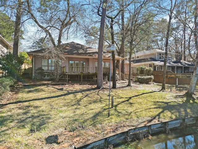 rear view of property featuring a yard and a deck