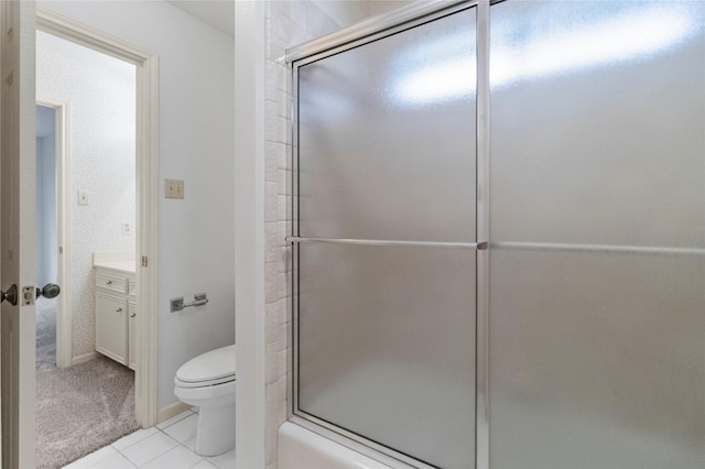 bathroom with toilet, vanity, a shower with door, and tile patterned floors