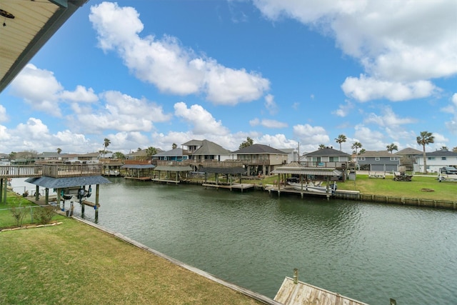 view of dock with a water view, boat lift, a residential view, and a lawn