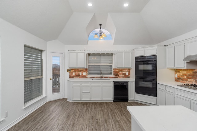 kitchen featuring light countertops, a sink, black appliances, and white cabinetry