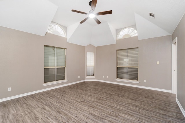 empty room featuring dark wood-style floors, ceiling fan, visible vents, and vaulted ceiling