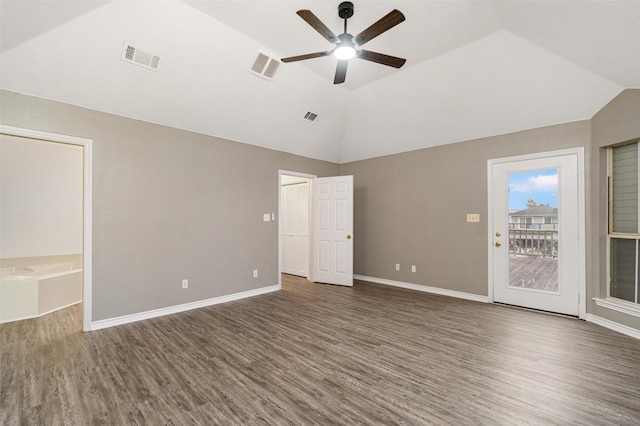 spare room with visible vents, vaulted ceiling, and dark wood-type flooring