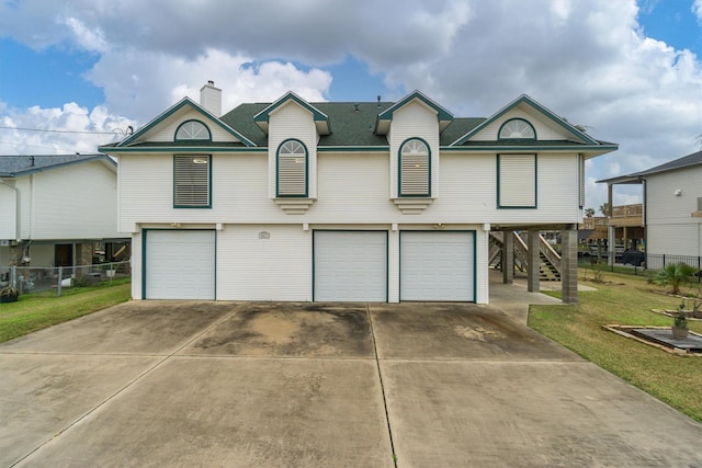view of front facade with an attached garage, concrete driveway, stairway, roof with shingles, and a carport
