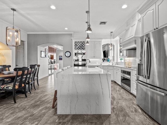 1250 Oahu Dr, Tiki Island, TX 77554 - kitchen with crown molding, a sink, a chandelier, arched walkways, and appliances with stainless steel finishes