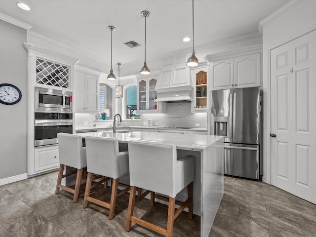 1250 Oahu Dr, Tiki Island, TX 77554 - kitchen with crown molding, a sink, glass insert cabinets, stainless steel appliances, and an island with sink