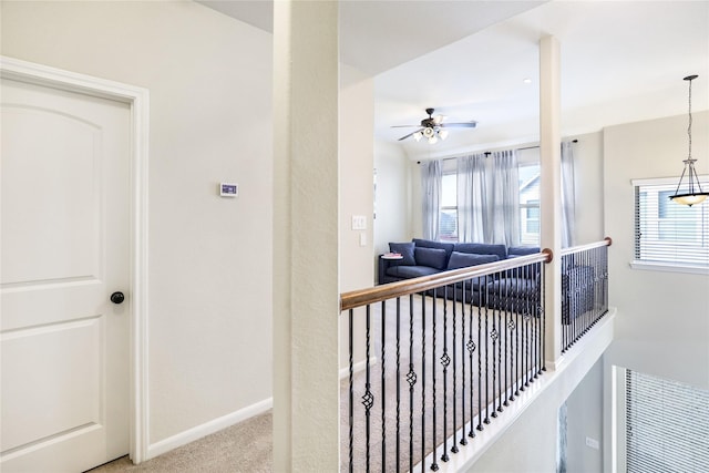 hall featuring visible vents, baseboards, and light colored carpet