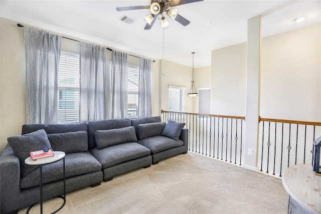 living area with a ceiling fan, light colored carpet, and visible vents