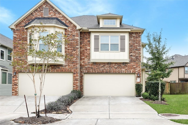 view of front of property with concrete driveway, brick siding, an attached garage, and fence