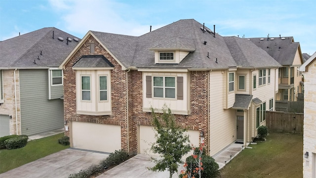 view of front of property featuring brick siding, a shingled roof, a garage, driveway, and a front lawn