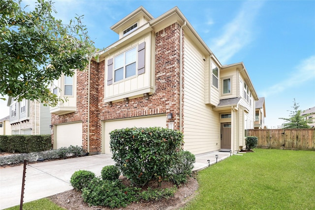 view of front of house featuring brick siding, a yard, concrete driveway, an attached garage, and fence