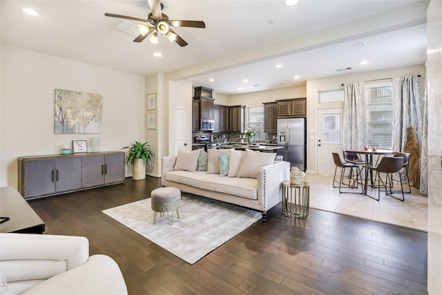 living room featuring dark wood-type flooring, recessed lighting, visible vents, and a ceiling fan