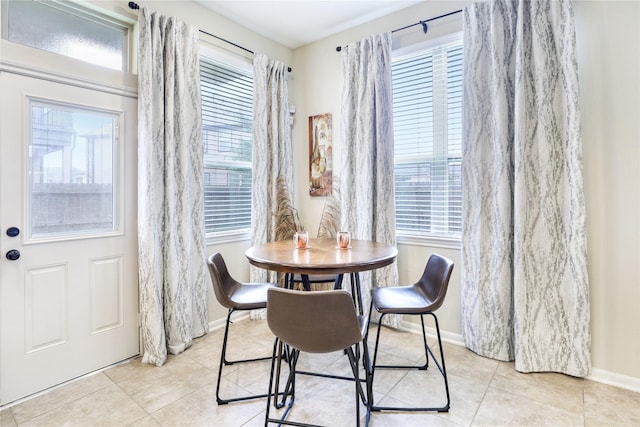 dining space featuring plenty of natural light, baseboards, and light tile patterned floors