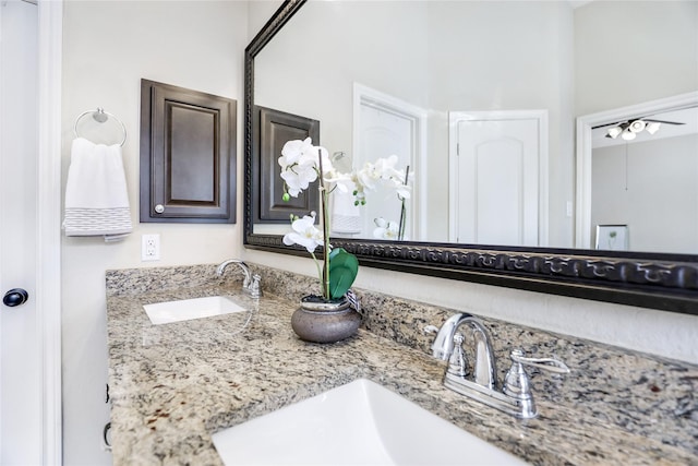 bathroom with ceiling fan, double vanity, and a sink