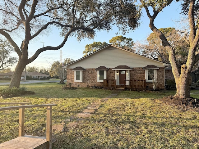 view of front of property with crawl space, brick siding, and a front lawn