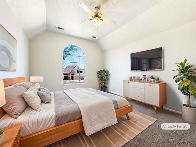 bedroom featuring lofted ceiling, a textured ceiling, and visible vents