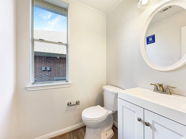 bathroom with toilet, wood finished floors, vanity, baseboards, and ornamental molding