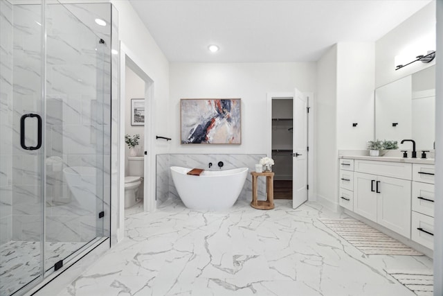 full bath featuring a marble finish shower, marble finish floor, a spacious closet, vanity, and a freestanding tub