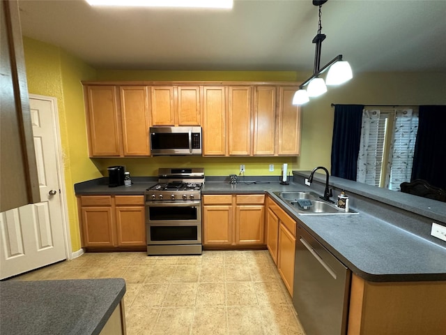 kitchen with stainless steel appliances, dark countertops, a sink, and hanging light fixtures