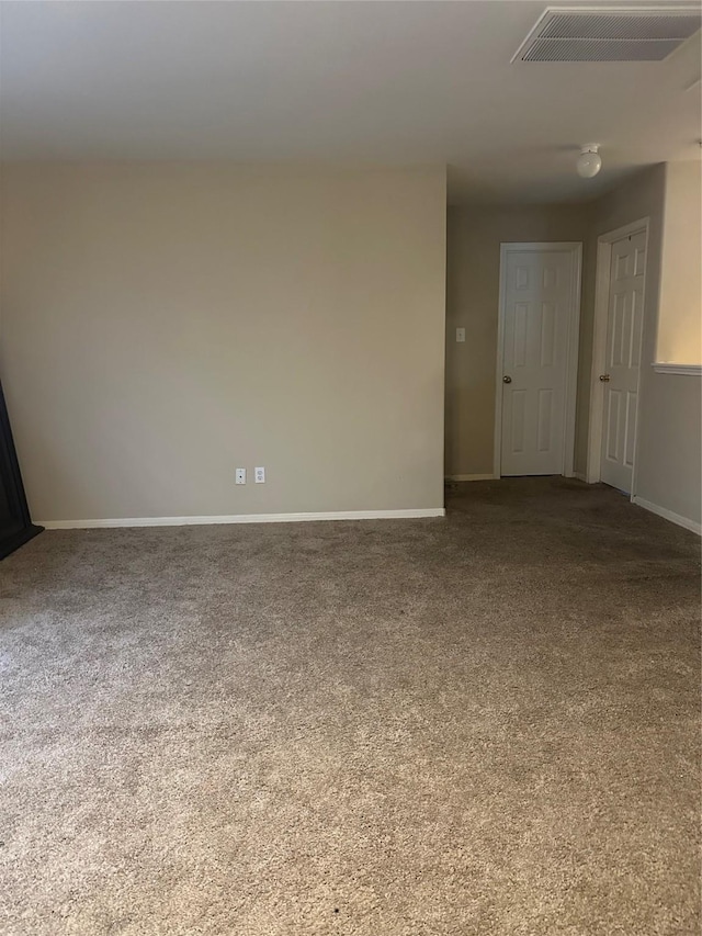 empty room featuring carpet, visible vents, and baseboards