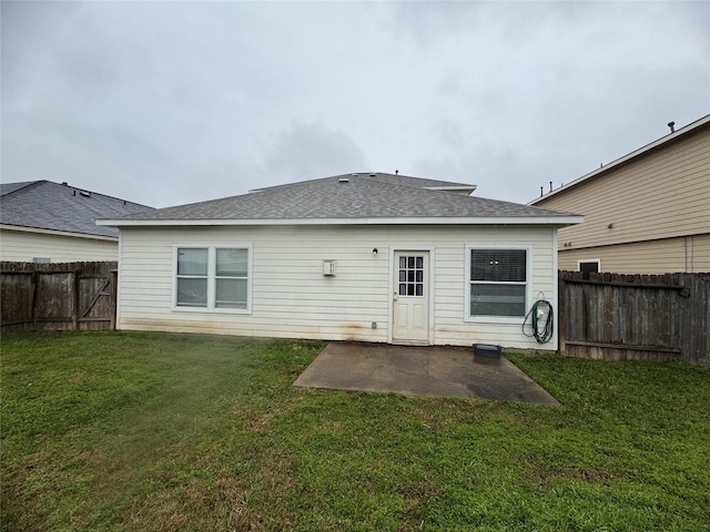 rear view of property with a patio area, a fenced backyard, a lawn, and roof with shingles