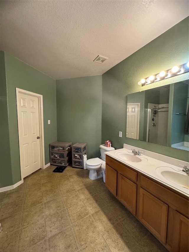 bathroom featuring double vanity, a sink, visible vents, and a shower stall