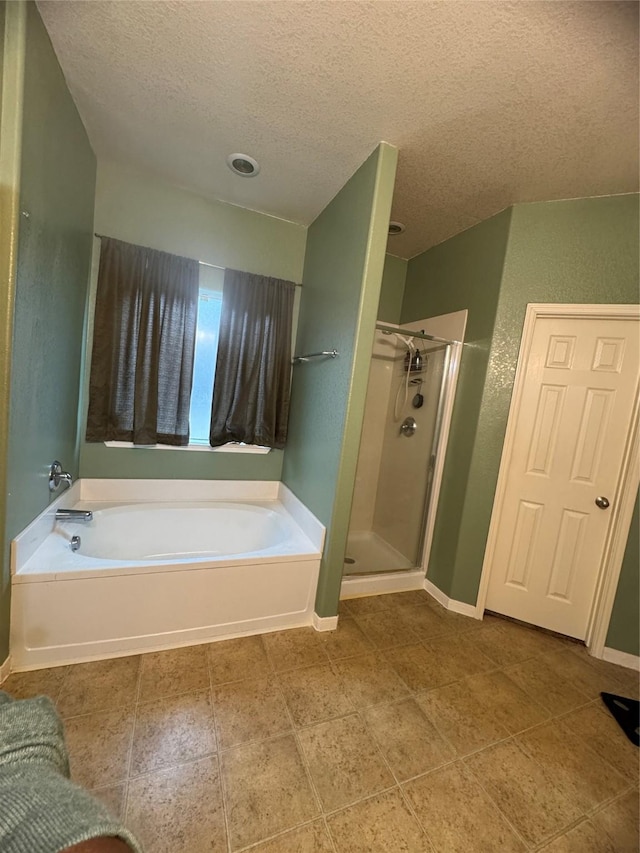 full bathroom with baseboards, a garden tub, a shower stall, and a textured ceiling