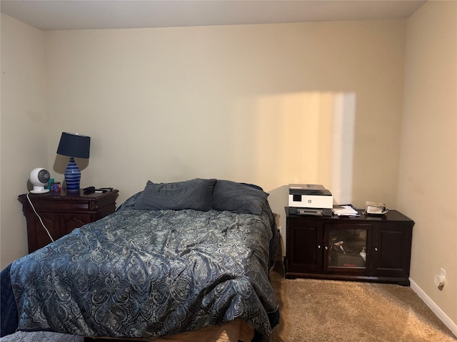 bedroom with light colored carpet and baseboards