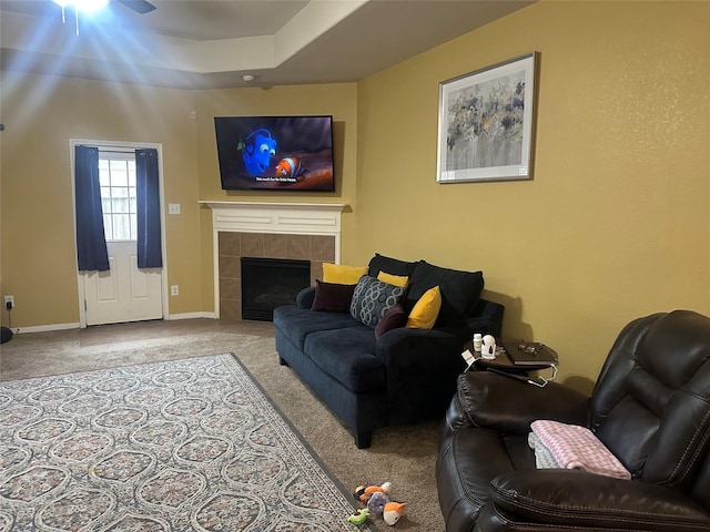 living room featuring carpet flooring, baseboards, and a tiled fireplace