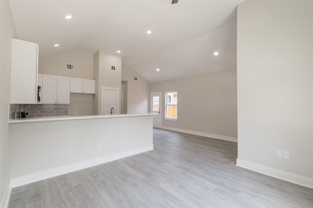 kitchen with light countertops, visible vents, open floor plan, white cabinets, and light wood-type flooring