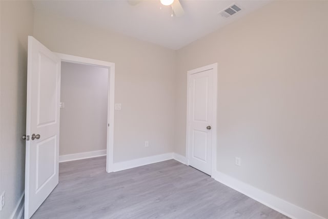 spare room with light wood-type flooring, baseboards, visible vents, and ceiling fan