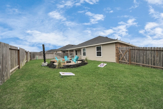 back of property with a fenced backyard, a fire pit, a lawn, and a patio