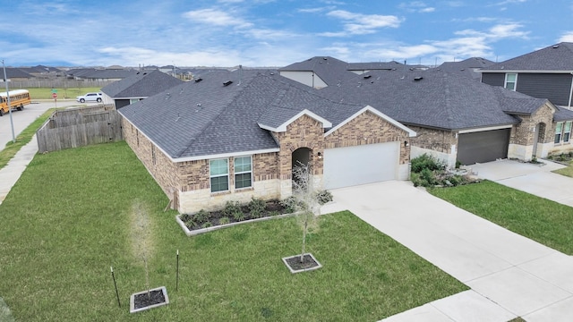 view of front facade with a residential view, fence, a front lawn, and roof with shingles