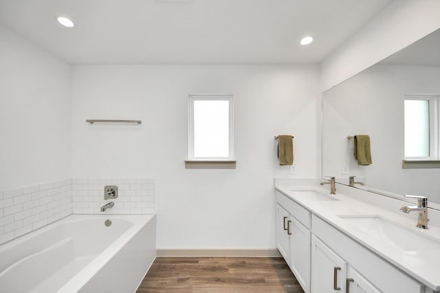 bathroom featuring a healthy amount of sunlight, a sink, and wood finished floors