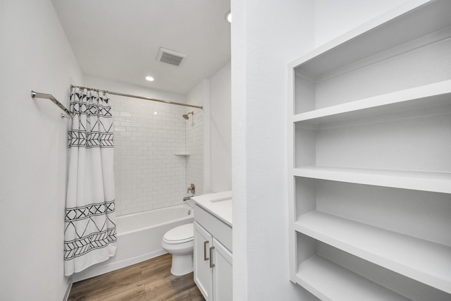 bathroom with visible vents, toilet, wood finished floors, shower / bath combination with curtain, and vanity