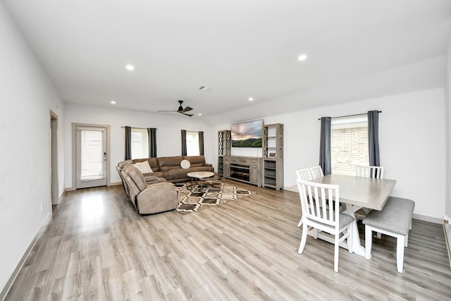 living room featuring light wood-type flooring, plenty of natural light, a fireplace, and recessed lighting