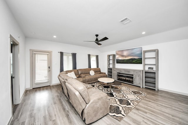 living room with recessed lighting, visible vents, a fireplace, and light wood finished floors