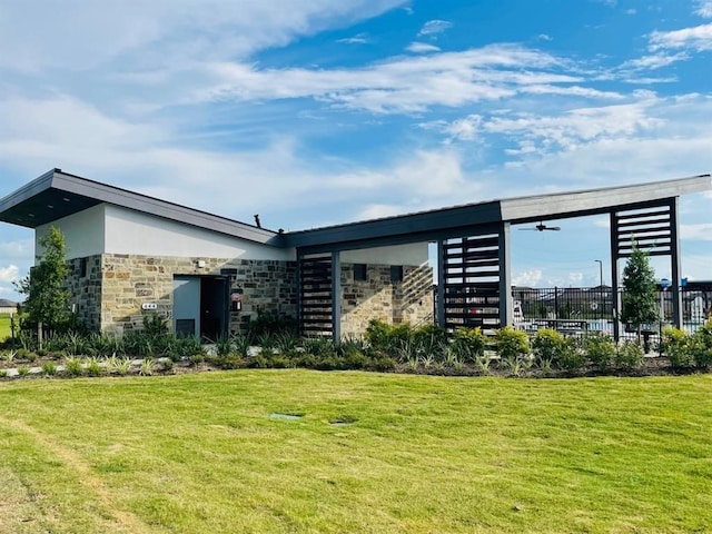 exterior space featuring stone siding, a yard, and stucco siding