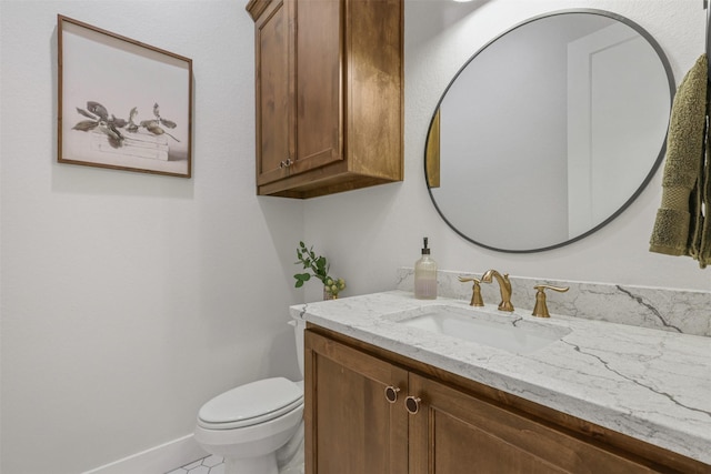 half bathroom with toilet, tile patterned floors, vanity, and baseboards