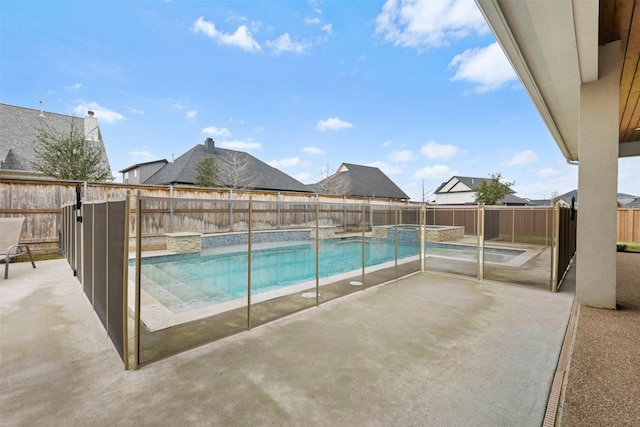 view of swimming pool with a pool with connected hot tub, a fenced backyard, and a patio