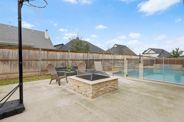 view of patio / terrace with a pool with connected hot tub, a fenced backyard, and a fire pit