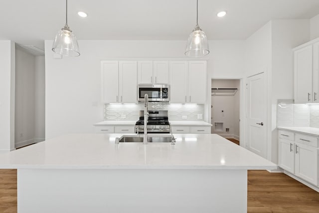 21659 Wave Hollow Dr, Cypress, TX 77433 - kitchen featuring appliances with stainless steel finishes, decorative backsplash, recessed lighting, and white cabinetry