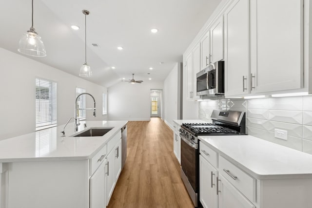 21659 Wave Hollow Dr, Cypress, TX 77433 - kitchen featuring stainless steel appliances, backsplash, light wood finished floors, light countertops, and open floor plan
