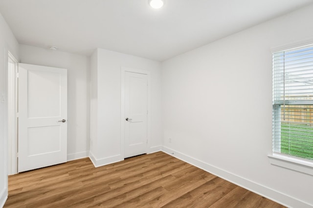 21659 Wave Hollow Dr, Cypress, TX 77433 - unfurnished bedroom with light wood-style floors and baseboards