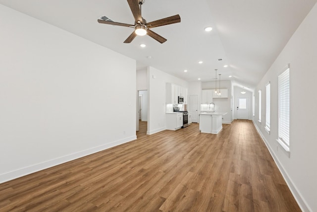 21659 Wave Hollow Dr, Cypress, TX 77433 - unfurnished living room with lofted ceiling, ceiling fan, light wood-style flooring, and recessed lighting