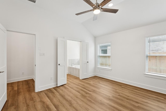 21659 Wave Hollow Dr, Cypress, TX 77433 - unfurnished bedroom with light wood finished floors, lofted ceiling, ensuite bath, and a ceiling fan