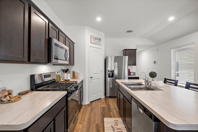 1730 Windstone Ridge Dr, Houston, TX 77014 - kitchen with stainless steel appliances, wood finished floors, vaulted ceiling, dark brown cabinets, and light countertops