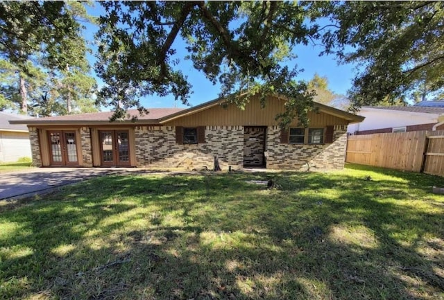 single story home with french doors, a front yard, fence, and brick siding