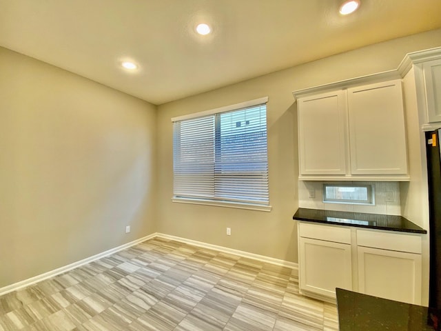 kitchen with baseboards, white cabinets, and recessed lighting