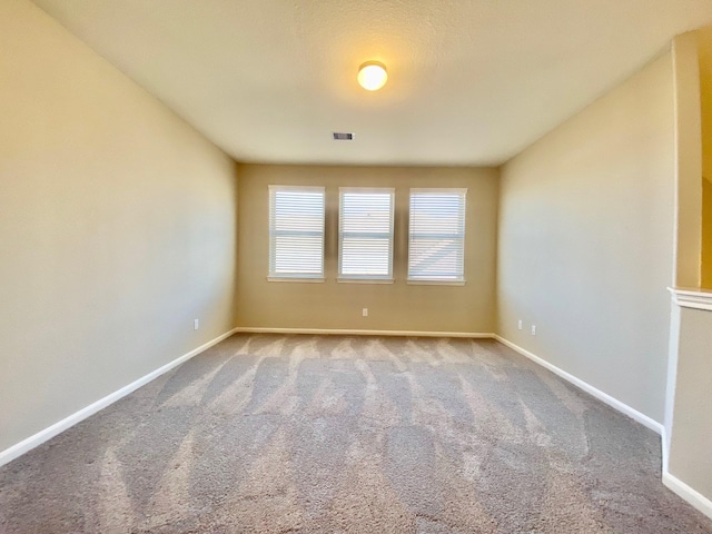 carpeted empty room with baseboards and visible vents